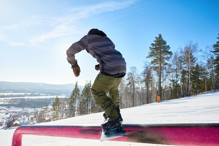 Snowboarder Riding on Rail